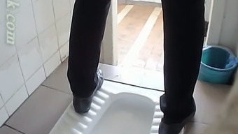 Light beginner girl in dark black pants pissing in the potty