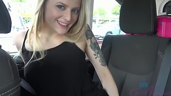 Paris White, a petite blonde with tattoos and long hair, reveals her hydrated vagina in an outdoor setting